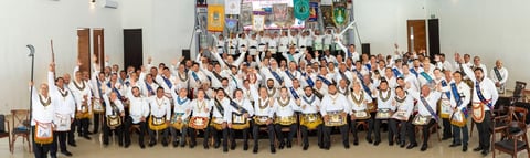 Foto grupal formal con bandas amarillas durante la ceremonia del Encuentro Masónico Peninsular.