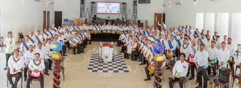 Gran grupo de asistentes en salón de paredes blancas y piso ajedrezado durante el Encuentro Masónico Peninsular.